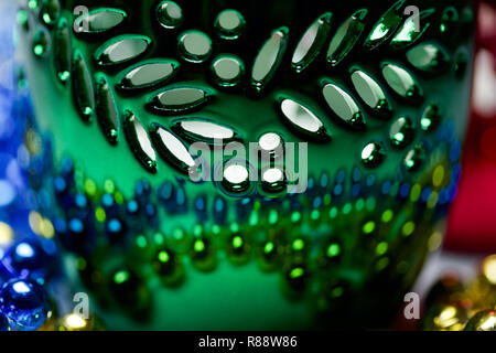 Metallic green candle holder macro abstract with reflecting colorful beads Stock Photo