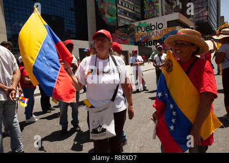 Venezuelans marching in city carrying Venezuelan flags, Caracas, Venezuela, South America Stock Photo