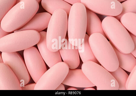 Top view of heap of light pink color oval shaped pills for background or banner Stock Photo
