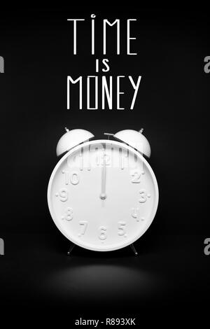 Time is money concept. Retro Alarm clock isolated on black background Stock Photo
