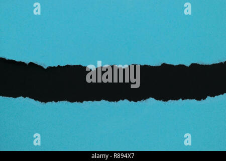 Blue ripped paper placed on black background paper with copy space Stock Photo