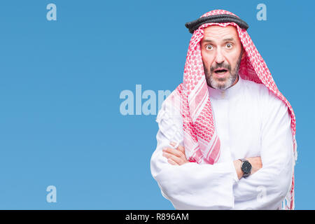 Senior arab man wearing keffiyeh over isolated background afraid and shocked with surprise expression, fear and excited face. Stock Photo