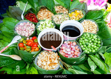 food wrapped in leaves / healthy food with leaf vegetable and herbs various in banana leaf with thai sauce in local food - thai herbs slice for cook f Stock Photo