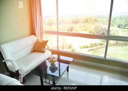 sofa in the morning room sunlight through open window / bedroom and white sofa pillow by the window glass home looking out nature background Stock Photo