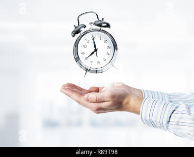 Concept of time management with clock in male palms. Mixed media Stock Photo