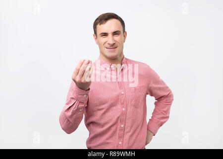 Young italian man doing a typical arguing italian gesture, looking straight ahead Stock Photo