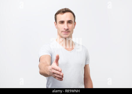 Young man gives handshake, greets with someone, , rejoices meeting. Stock Photo