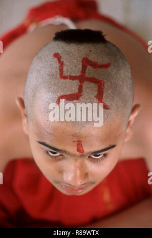Red swastik symbol on bald head at Indian boy during thread ceremony Bombay Mumbai Maharashtra India Stock Photo