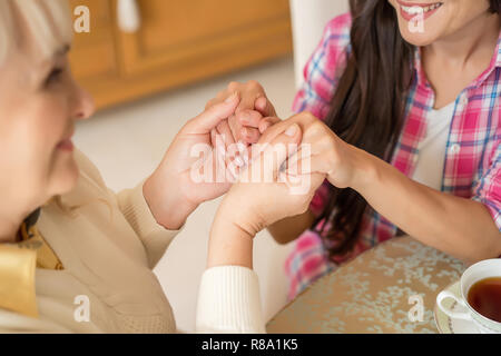 Cropped Shot Of Women Holding Hands Together Tight. Top View. Mother Holds Hands Of A Daughter Stock Photo