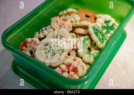 Homemade butter spritz Christmas cookies packed in a green plastic container for easy transport to a party Stock Photo