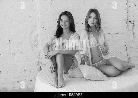 Lesbians in sexy lingerie in a white room Stock Photo Alamy