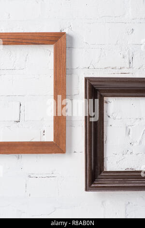 brown and black empty frames hanging on white brick wall Stock Photo