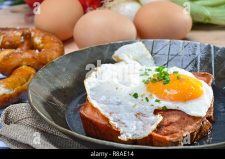 Fried meat loaf with an egg sunny side up in an iron pan Stock Photo