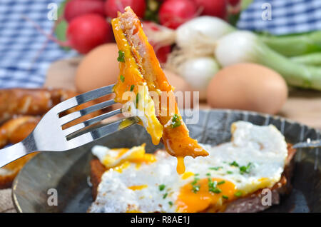 Fried meat loaf with an egg sunny side up in an iron pan Stock Photo