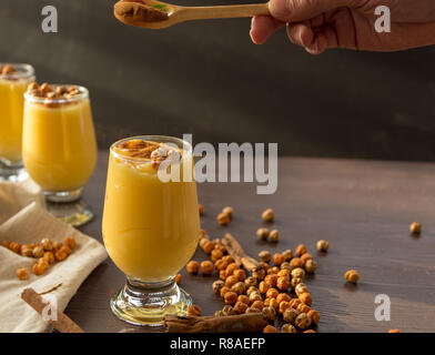 boza or bosa, a traditional Turkish drink roasted chickpeas and cinnamon on the brown table Stock Photo
