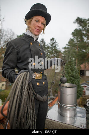 13 December 2018, Brandenburg, Königs Wusterhausen: Stephanie Frenk, chimney sweep master, stands on the roof of a house. She is one of the few chimney sweeps in Brandenburg. She lives and works in the area of Königs Wusterhausen (Dahme-Spreewald). She received her master's certificate in 2011. Every year she climbs several thousand house roofs to clear the chimneys of soot and ash. Photo: Patrick Pleul/dpa-Zentralbild/ZB Stock Photo