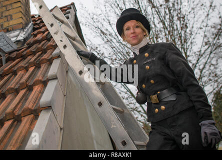 13 December 2018, Brandenburg, Königs Wusterhausen: Stephanie Frenk, chimney sweep master, climbs onto the roof of a house. She is one of the few chimney sweeps in Brandenburg. She lives and works in the area of Königs Wusterhausen (Dahme-Spreewald). She received her master's certificate in 2011. Every year she climbs several thousand house roofs to clear the chimneys of soot and ash. Photo: Patrick Pleul/dpa-Zentralbild/ZB Stock Photo