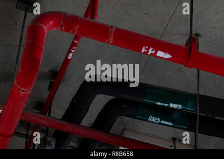 Fire sprinkler system with red pipes hanging from ceiling inside building. Fire Suppression. Fire protection and detector. Main supply water piping in Stock Photo