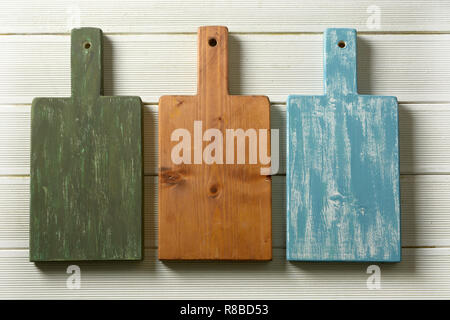 three colored cutting boards on white table - closeup Stock Photo
