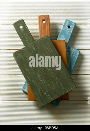 three colored cutting boards on white table - closeup Stock Photo