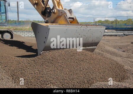 A Caterpillar 320E levelling out lightweight expanded clay aggregate , which is used for backfilling behind a railway bridge on the FARRRS link road. Stock Photo