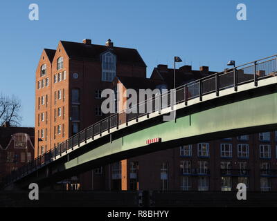 Bremen, Germany - Steel bridge across the river Weser leading to the Teerhof peninsula with red brick buildings in the background under a clear blue s Stock Photo