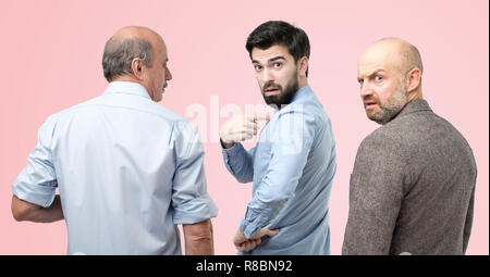Are you talking about me concept. Horizontal portrait of three man, having doubtful confused uncertain facial expression Stock Photo