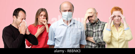 Horizontal portrair of several men and women having flu. Men in the middle wearing special mask trying not to get ill. Stock Photo