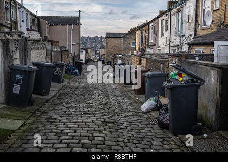 Wheelie bins and rubbish in a back alley in the former mill town of  Nelson, Lancashire Stock Photo