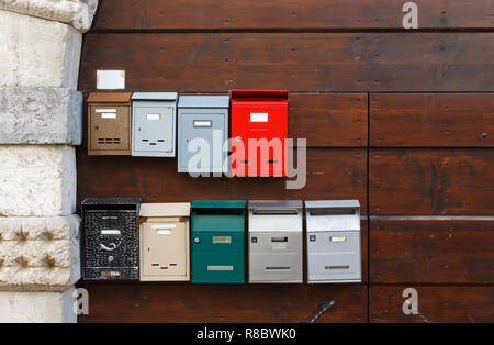 Two rows of mailboxes on the wooden gate of a traditional house Stock Photo