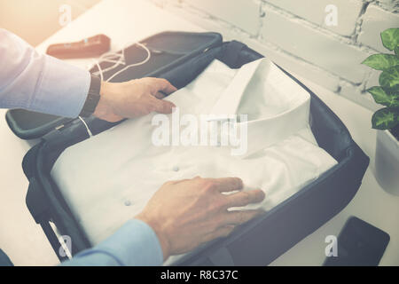 man packing travel suitcase for business trip Stock Photo
