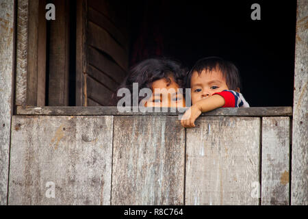 Children looking out of their hut in Iquitos,Peru Stock Photo