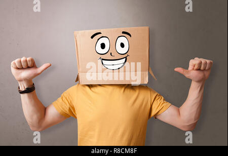 Young boy standing and gesturing with a cardboard box on his head  Stock Photo