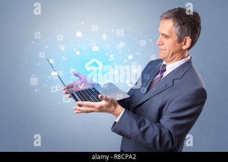 Man holding laptop projecting notifications, symbols and information based on cloud technology system  Stock Photo