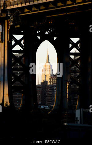 Spectacular view of the Empire State Building seen through the Manhattan bridge in Dumbo neighborhood. Dumbo is a neighborhood in New York City. Stock Photo