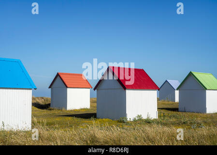 Row of colourful beach cabins in the dunes at Gouville-sur-Mer, Lower Normandy, France Stock Photo