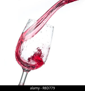 red wine pouring into glass isolated on white background, studio photo Stock Photo