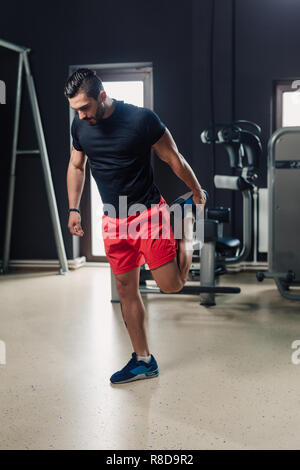 Strong bearded man in the gym stretching Stock Photo