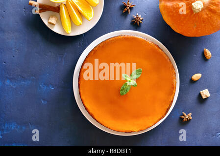 Healthy Pumpkin and orange pie on blue stone background with copy space. Traditional autumn dish. Healthy vegetarian food. Top view, flat lay Stock Photo