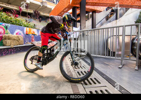 Cyclist touring the track on the electric stairs in Comuna Trece during the Downhill Challenge Medellin 2018. Cycling event that was held this Decembe Stock Photo