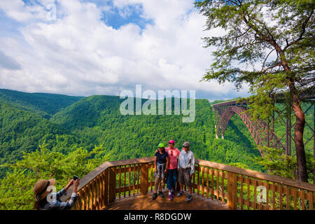 Tourist pose for cell phone camera on observation deck with view of New River Gorge and the New River Gorge Bridge in New River National Park. Stock Photo