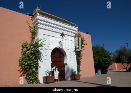 A female tourist dressed all in white poses in the doorway of a traditional Moroccan building Stock Photo