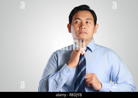 Photo image portrait of a handsome attractive successful young Asian businessman adjust his neck tie Stock Photo