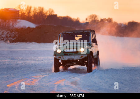 Russian UAZ 469 moving on ice of a frosn river at sunset Stock Photo