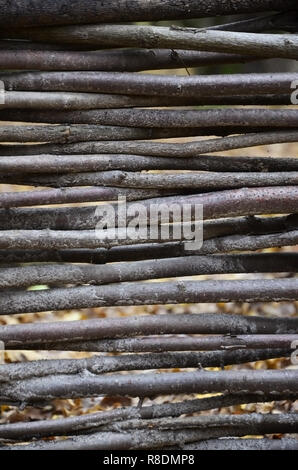 Decorative fence from wooden branches. Rare wooden wall Handmade small wooden thin branches in Ukrainian western style Stock Photo