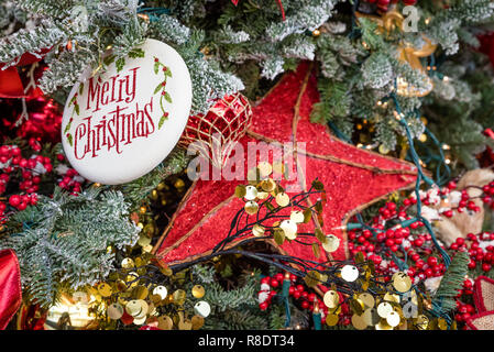 Christmas tree decorated with Merry Christmas ornament and large red star Stock Photo