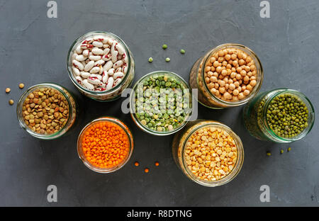 Died lentils and pulses in open glass kitchen jars for storage view top down, healthy ingredients for vegetarian cuisine Stock Photo