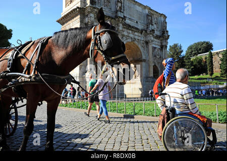 ROME, Italy – October 09, 2018:  A Man in wheelchair enjoying outdoors roman vacations. On the background the Arch of Constantine and the horse for th Stock Photo