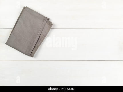 Grey dishcloth on white wooden plank table flat lay top view from above with copy space Stock Photo