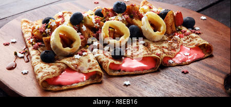 Delicious Tasty Homemade crepes or pancakes with apple, banana and blueberries Stock Photo